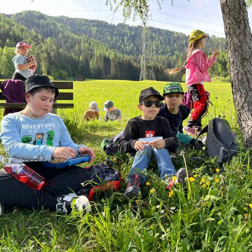 Kinder sitzen in der Wiese 