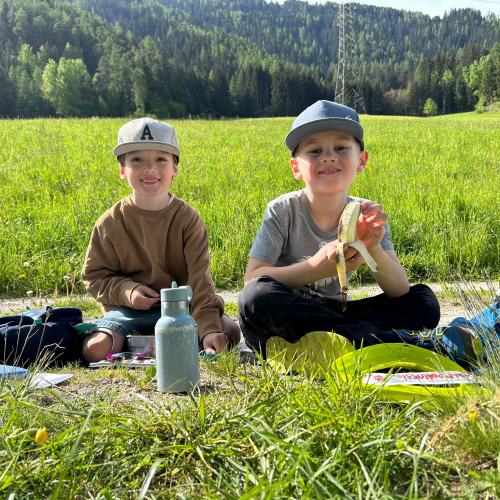Kinder sitzen in der Wiese 