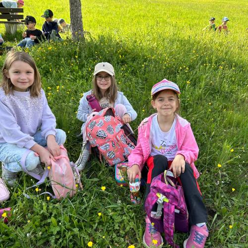 Kinder sitzen in der Wiese 