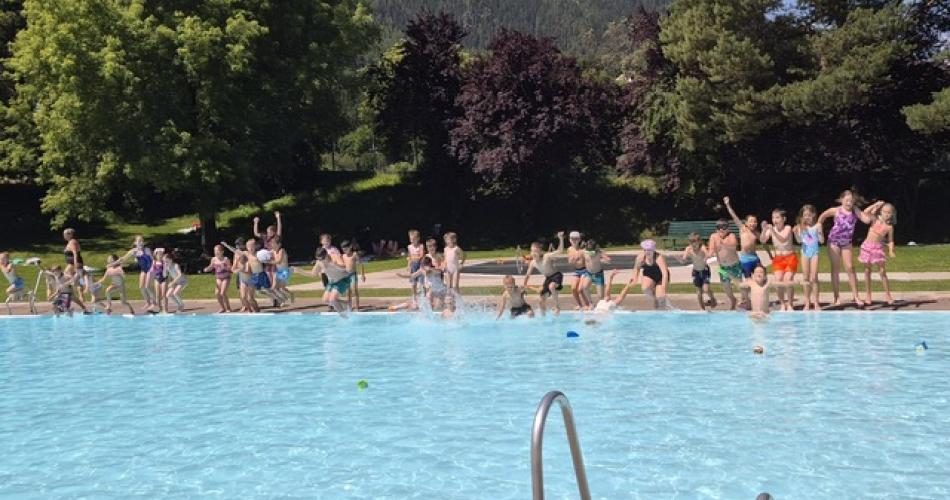 Kinder springen gemeinsam in das Schwimmbecken